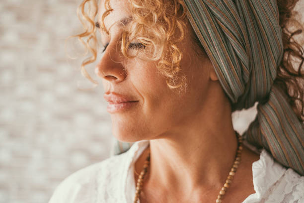 Woman with curly hair and a headscarf, embodying natural skin care and balance.